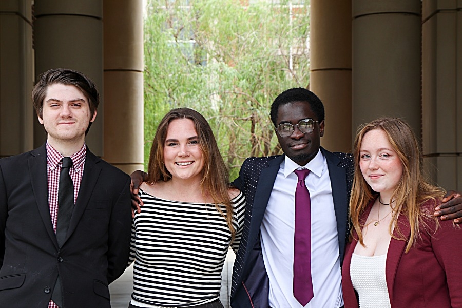 Four O U students stand outside of Gould Hall. 