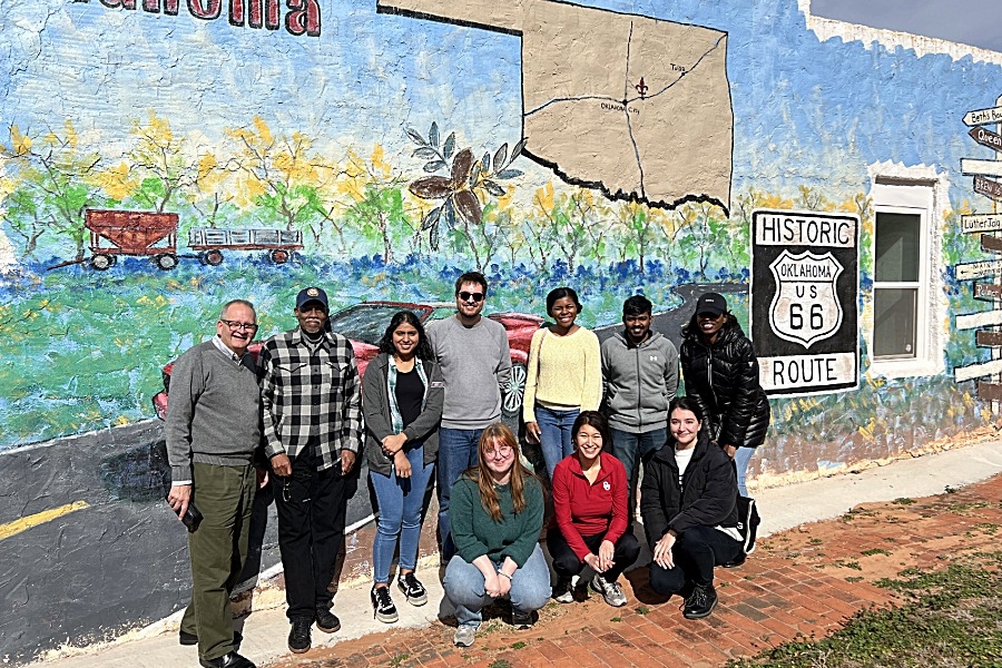 Students in Institute for Quality Communities stand infront of OKC wall mural. 