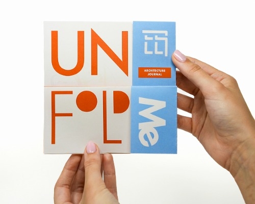a pair of hands holding and showing the cover of a Telesis section