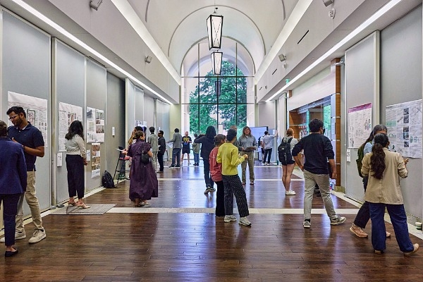 A large group of students presenting their work in Gould Gallery. 