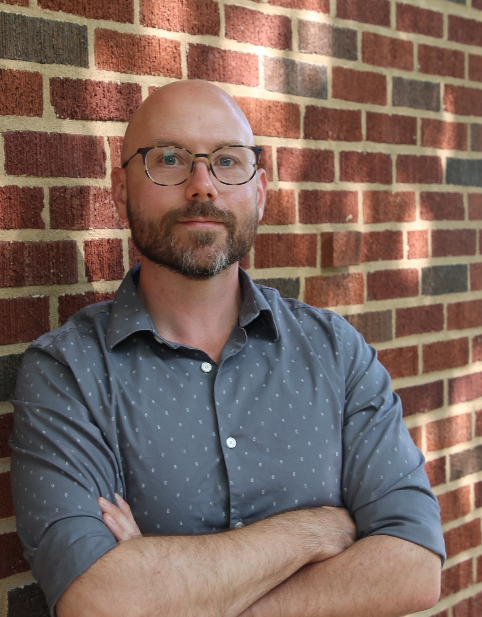 David Allen David Allen, gray shirt, arms crossed, with a brick wall behind him