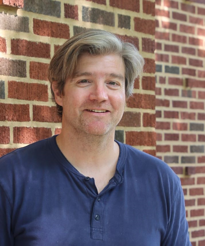 Thomas Smith Thomas Smith, blue shirt, with a brick wall behind him
