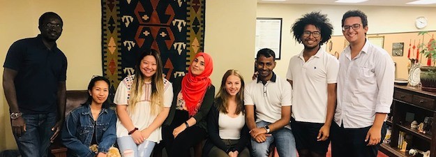 Eight students sitting together and smiling.