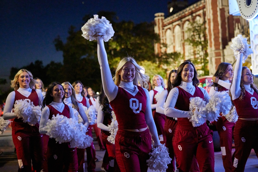 Cheerleaders at the glow parade in front of the Bizzell Library.