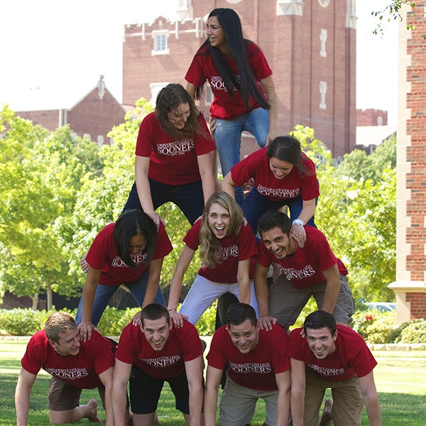 Students forming a human pyramid outside.