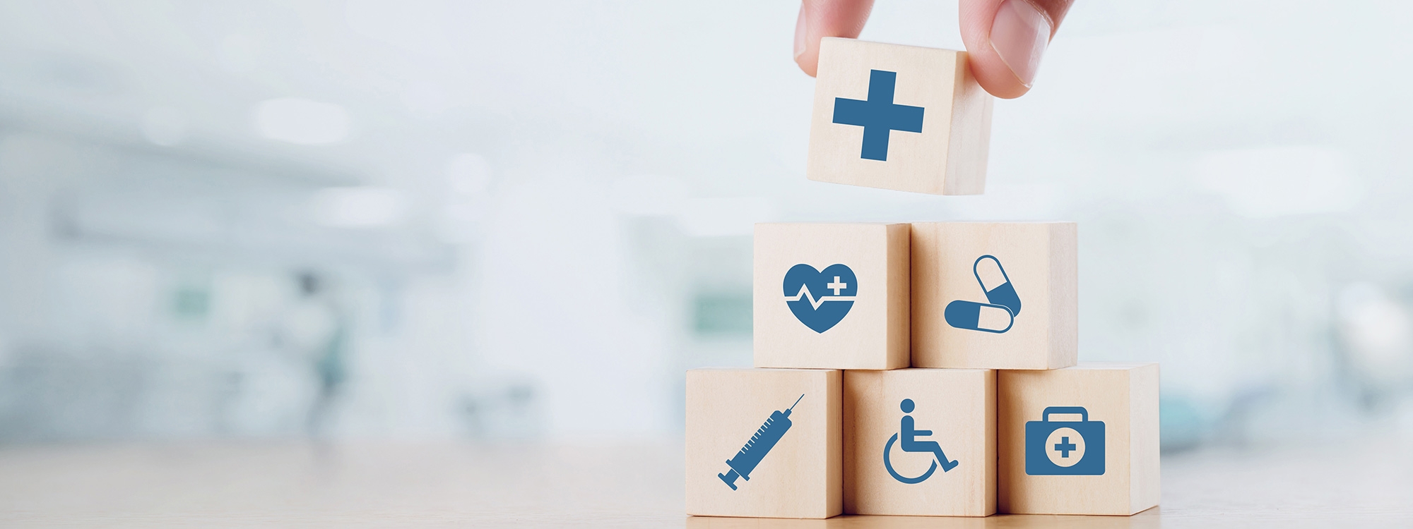 Wooden blocks with different health icons on them being stacked into a triangle.