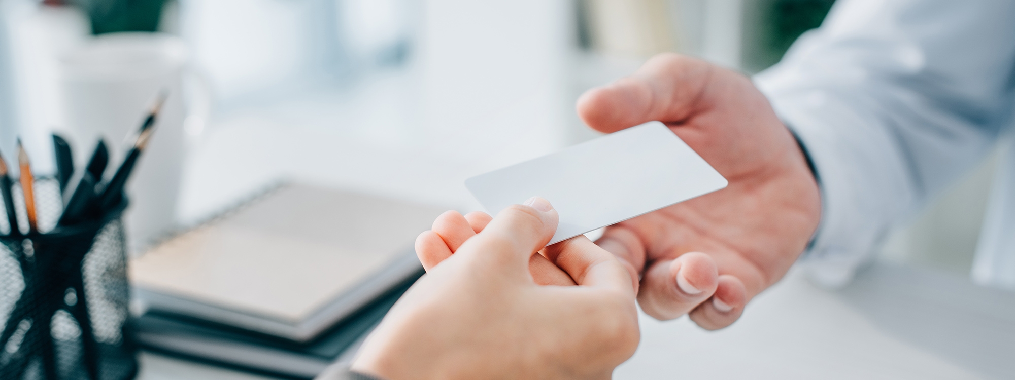 Patient handing their health id card to a healthcare professional.