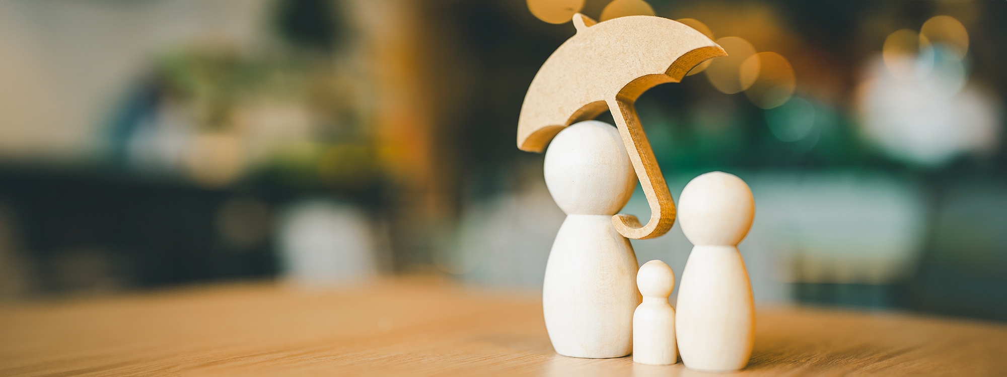 Simple wooden figures holding an umbrella.
