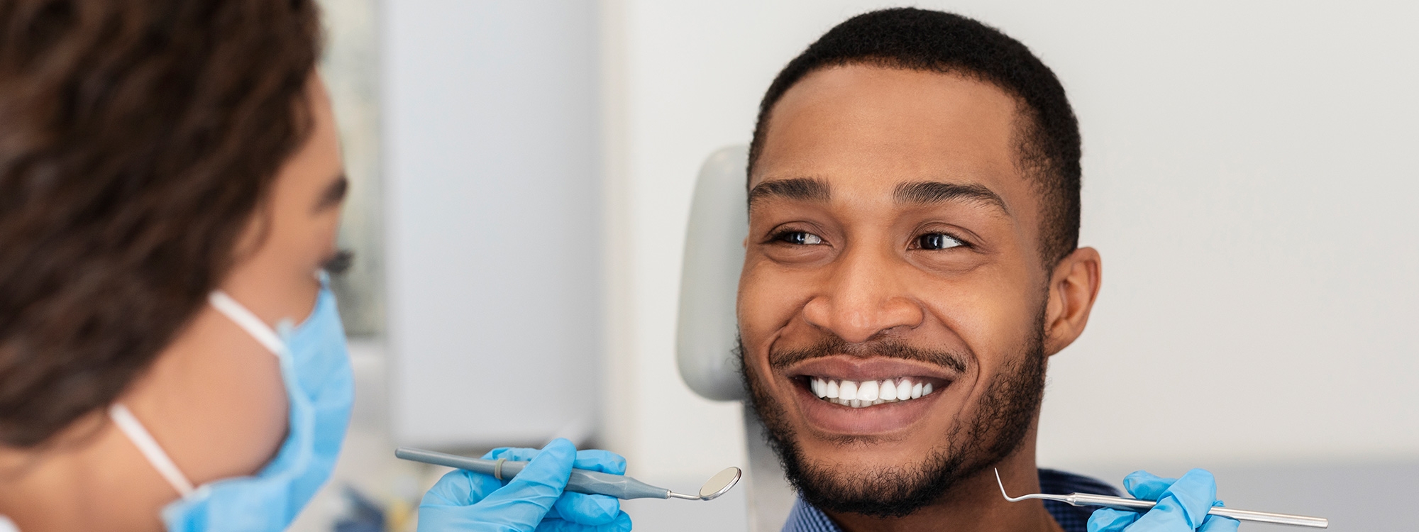 A man smiling in a dental chair.