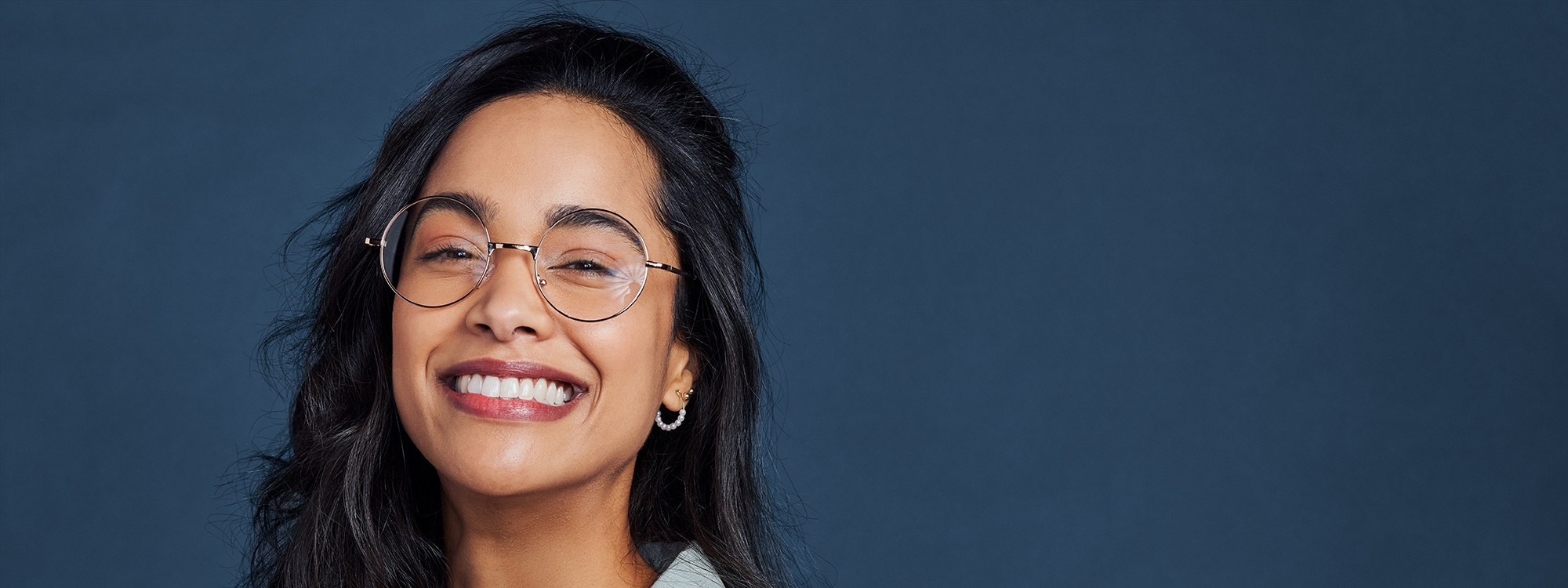 Woman with glasses smiling.