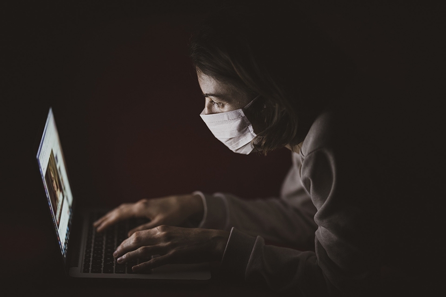 Girl in mask on a computer