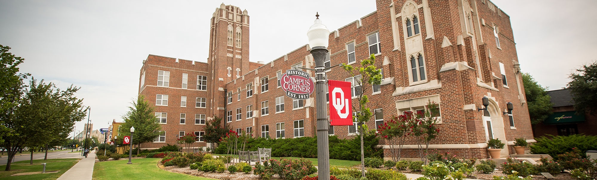 Whitehand Hall with lamp posts with an OU flag beside it