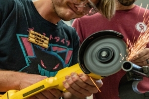 A grinder throwing sparks while grinding metal.