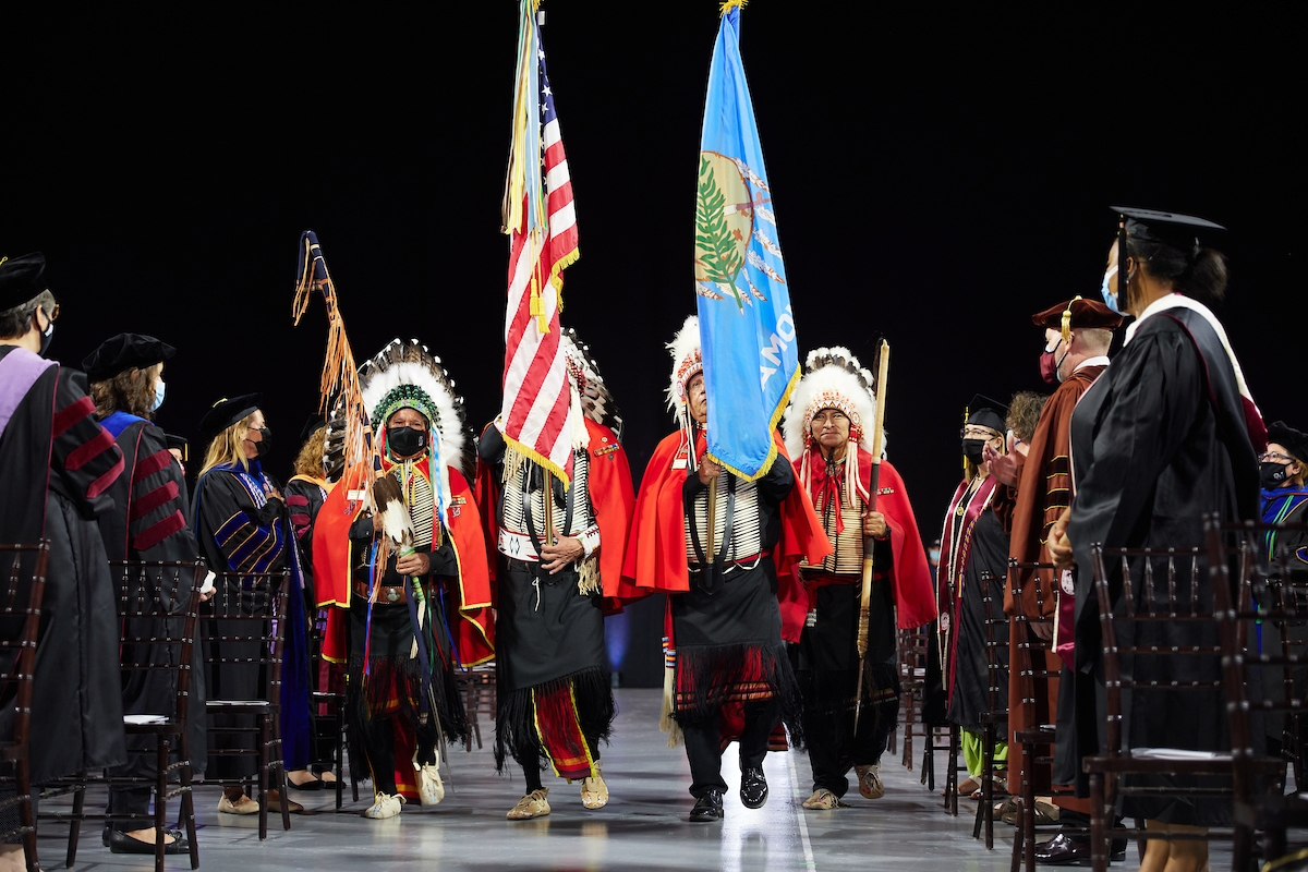 Kiowa members in traditional dress present flags of US and OK at event