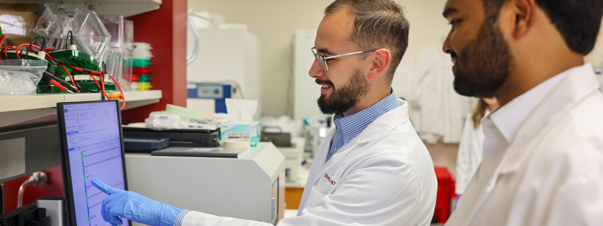 Two O U Health Graduate College students working in a laboratory.