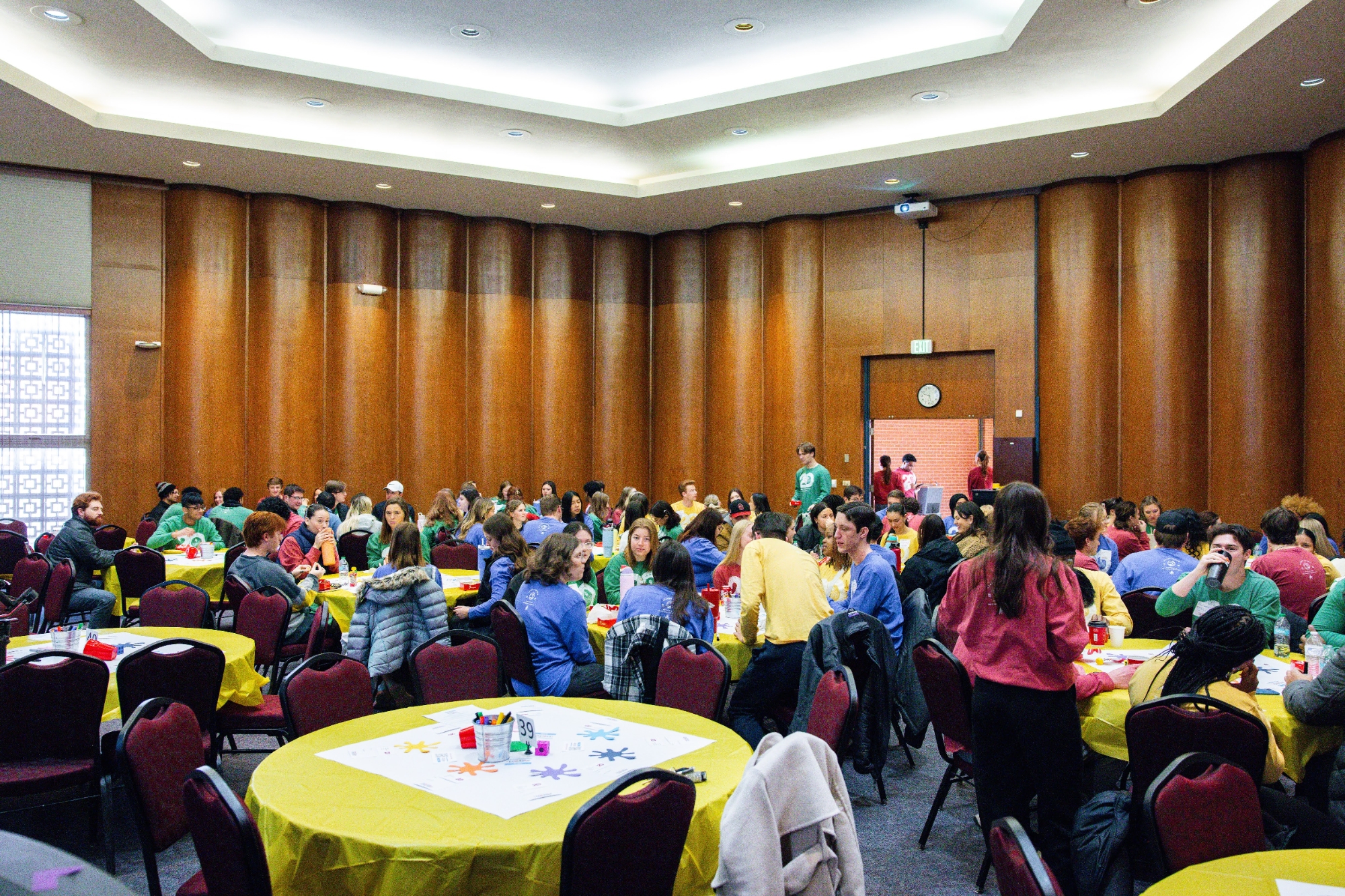A wide shot of a room full of students sitting at tables at the 2025 Leader Summit.
