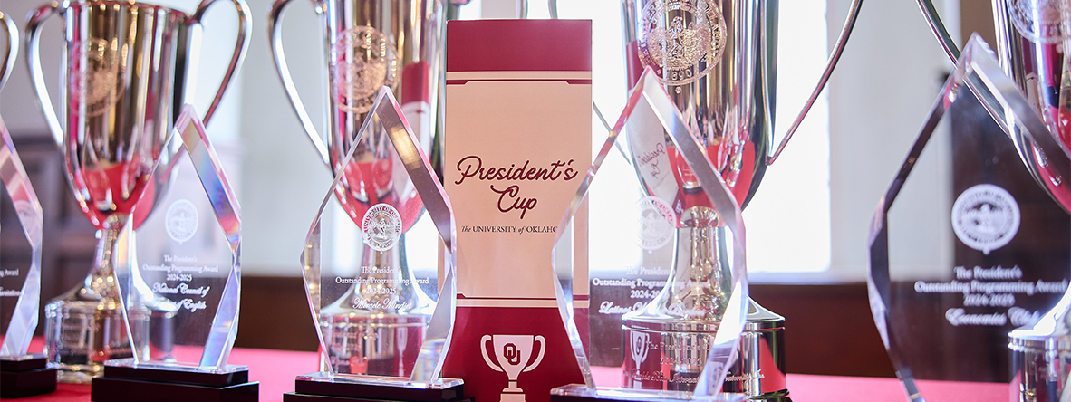 A table with awards and an event program for the President's Cup ceremony.