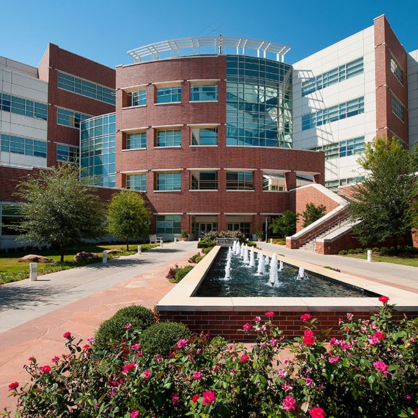 A fountain and flowers in front of the National Weather Center entrance.