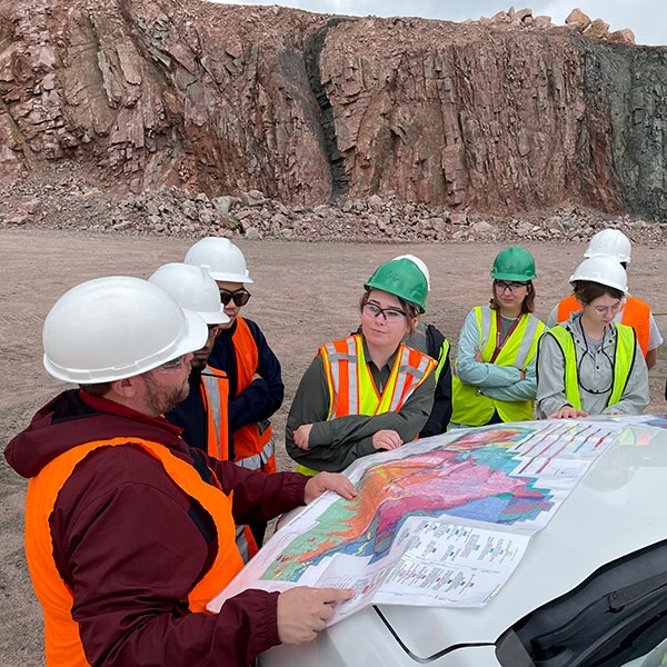 A professor showing students a map during a field trip.