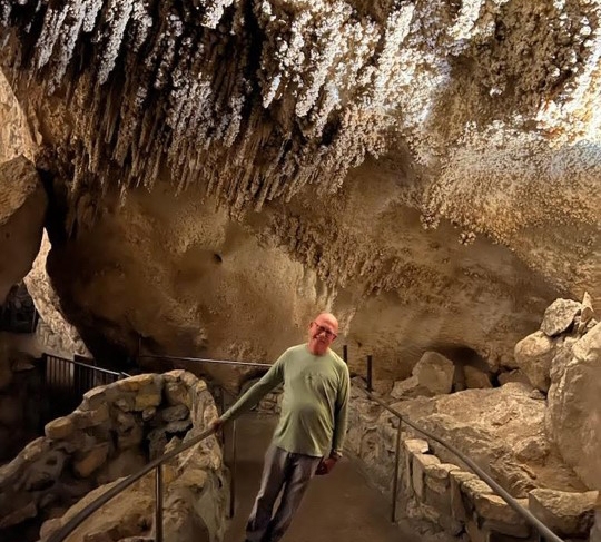 A professor standing in a cave.