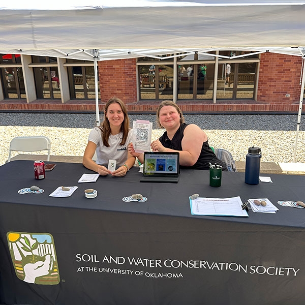 Two students at a tabling event.
