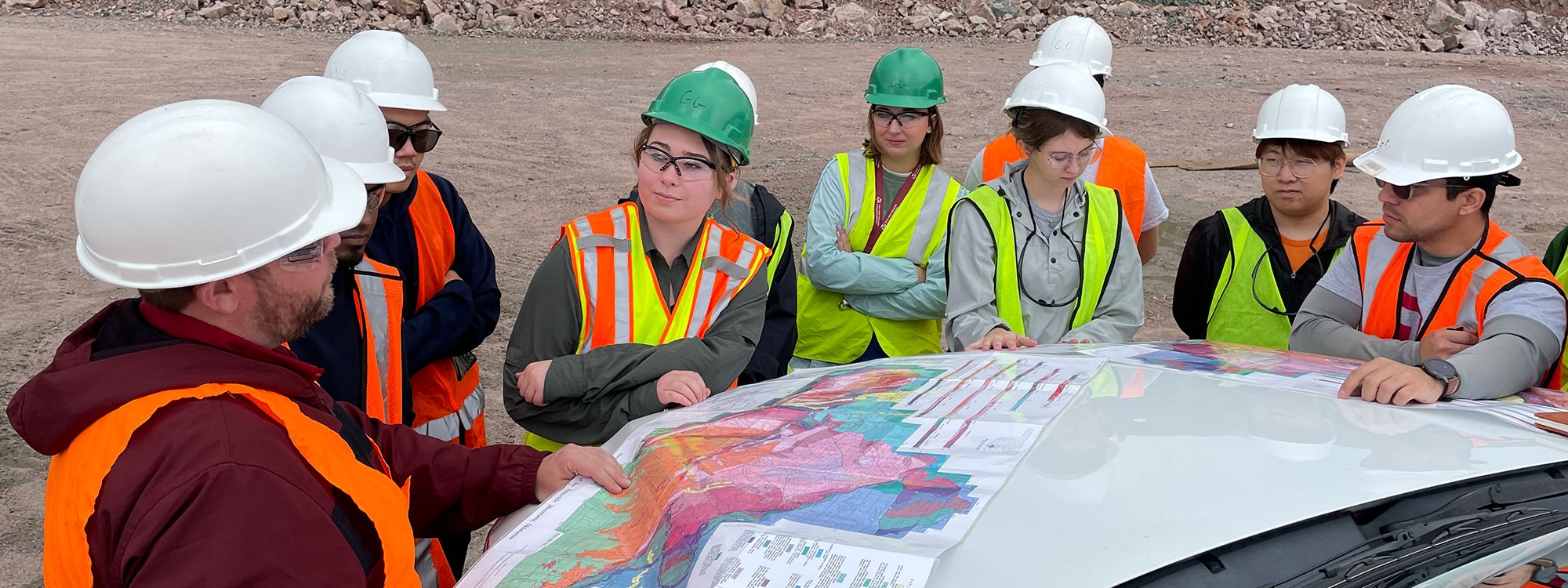 A professor showing students a map during a field trip.