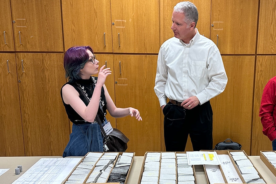 A professor and student working on a computer for research.