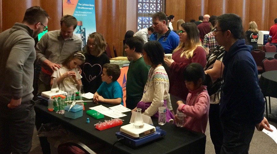 OU students helping kids with a microscopy demonstration