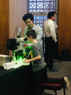 OU students helping kids use a fluorescence microscope