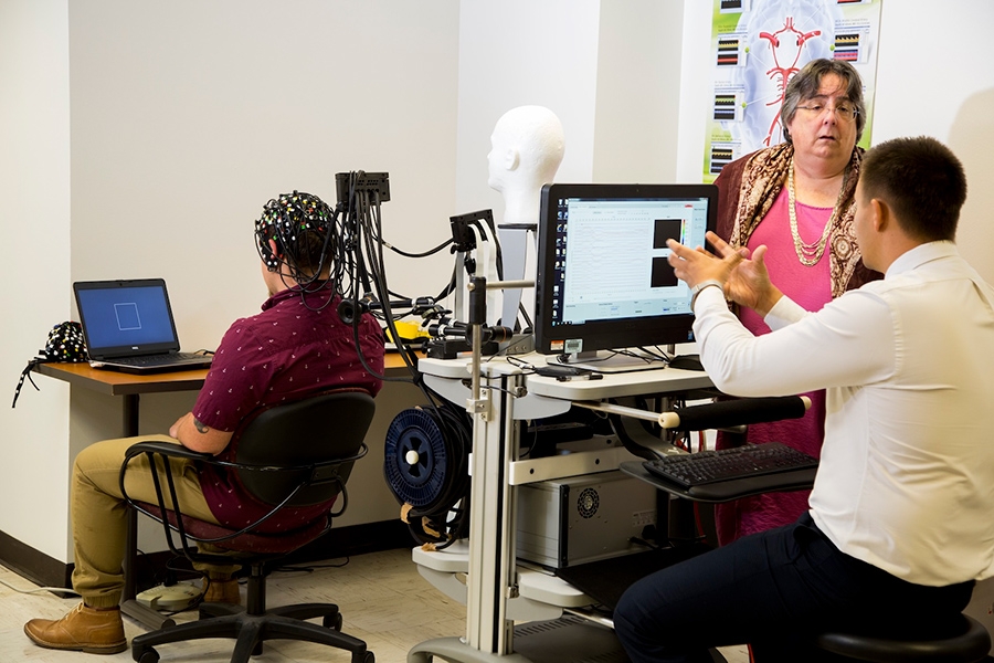 Researchers in the Translational Gerosciece Laboratory at OU Health Sciences measure blood flow to the brain by placing what looks like a swim cap with light sensors on a person’s head.