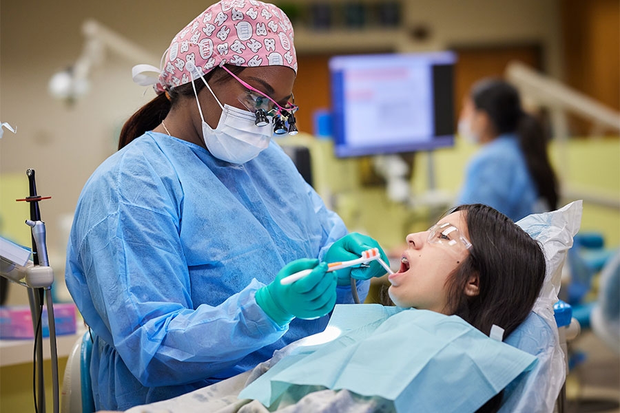 A female dentist working on a young girl.