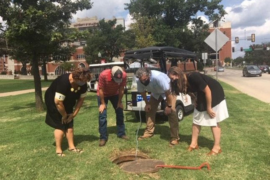 The University of Oklahoma Wastewater Surveillance Team takes samples from a manhole in Oklahoma to look for foodborne pathogens. 