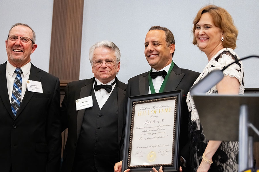 Dennis Case, Phil Moss, Joseph Harroz, and Allison Garritt pose for a picture as Harris receives his award.
