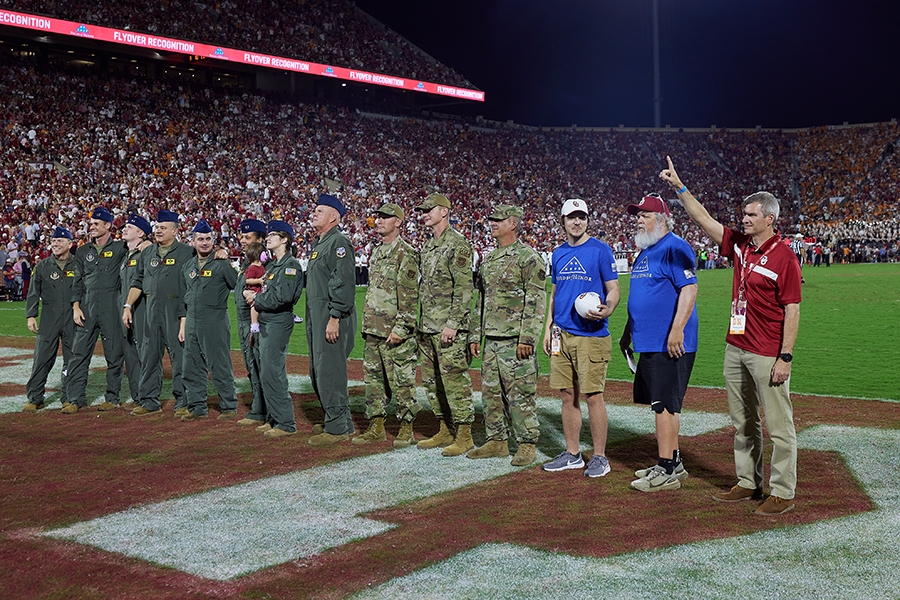Jason “Mongoose” Dotter (right), a U.S. Air Force pilot and former member of the Pride of Oklahoma, was recognized alongside five OU alumni and current KC-135 flyover crew members from the 507th Air Refueling Wing from Tinker Air Force Base, during the home OU football game against Tennessee. Christopher Schneider (third from right), an OU graduate who is currently pursuing a graduate degree in mechanical engineering, also received the Folds of Honor scholarship in honor of his father, U.S. Air Force Major Charles Schneider (second from right).