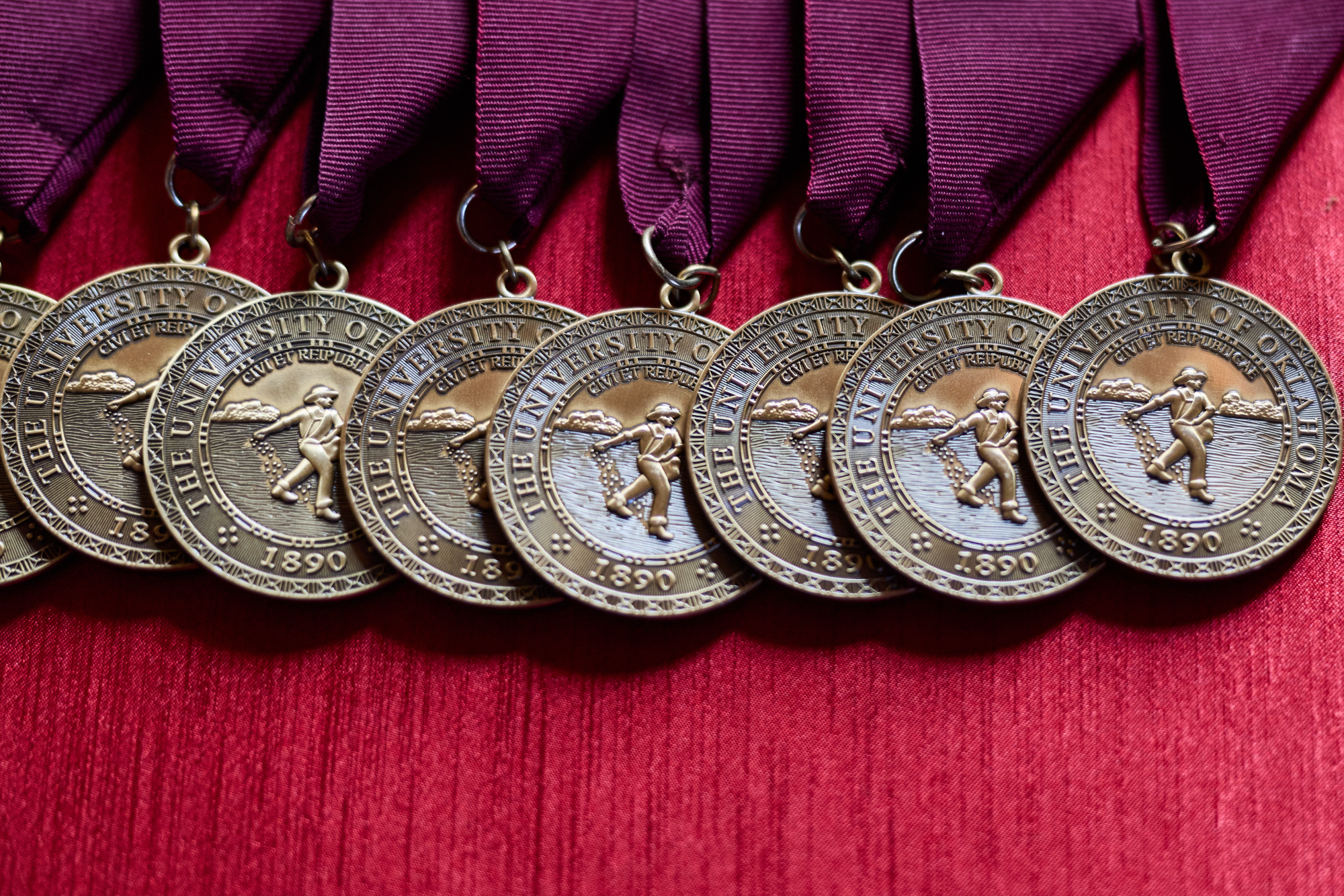 Medals lying on a red tablecloth.