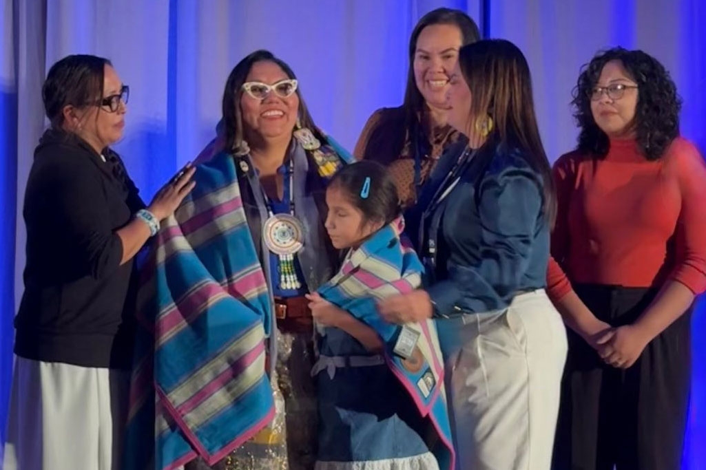 A group of people standing in front of a blue curtain.