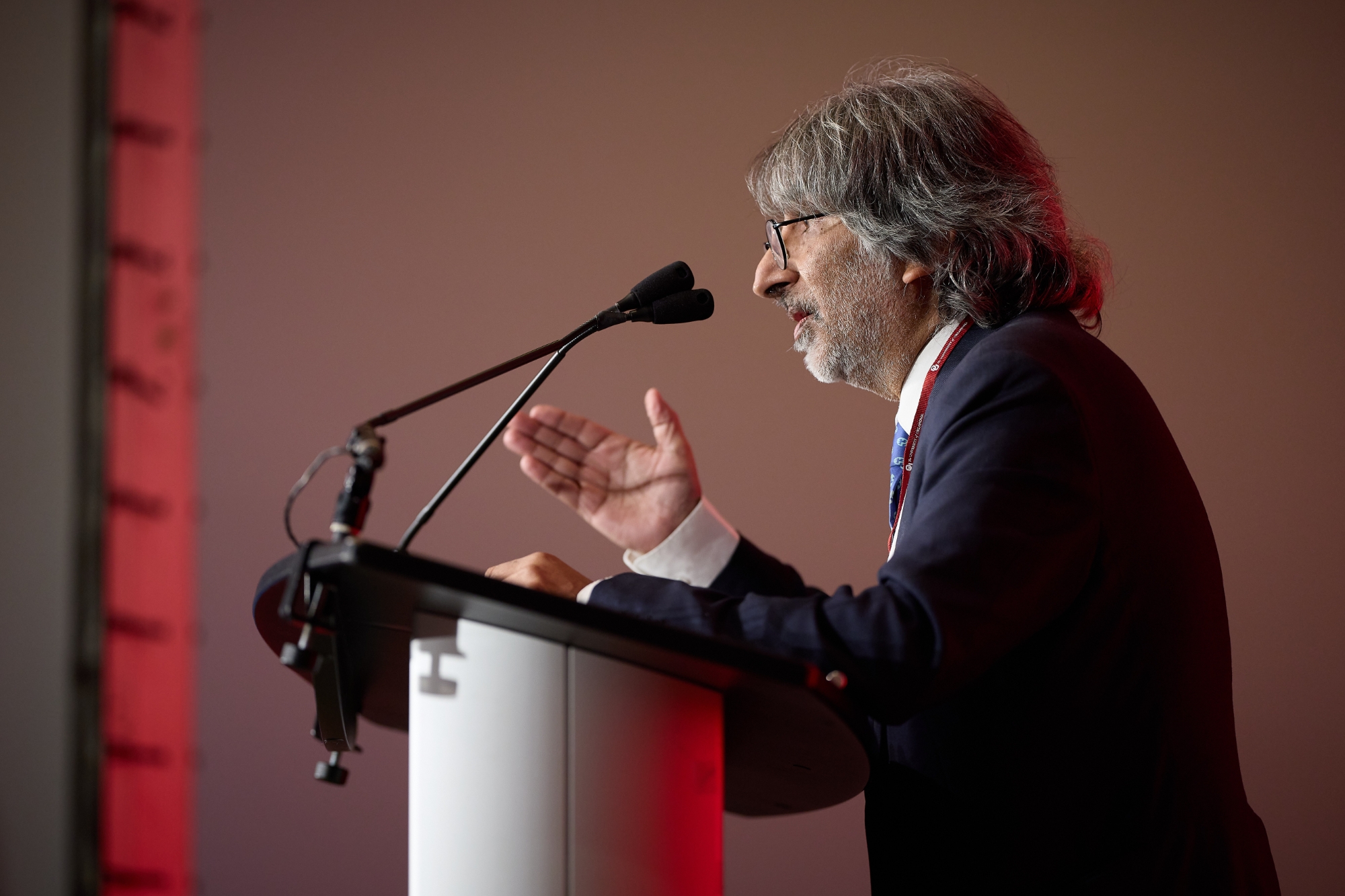 Amar speaking in front of a microphone.