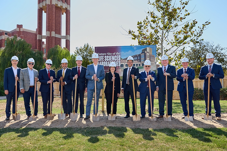 Twelve people pose for a groundbreaking photo.