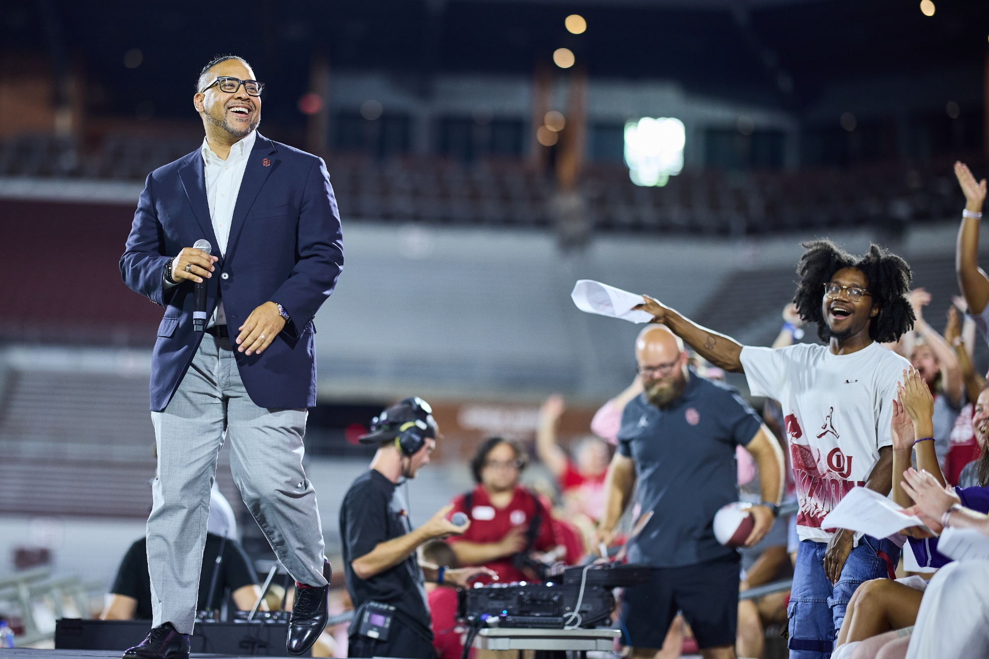 David Surratt walking across a stage as students cheer. 