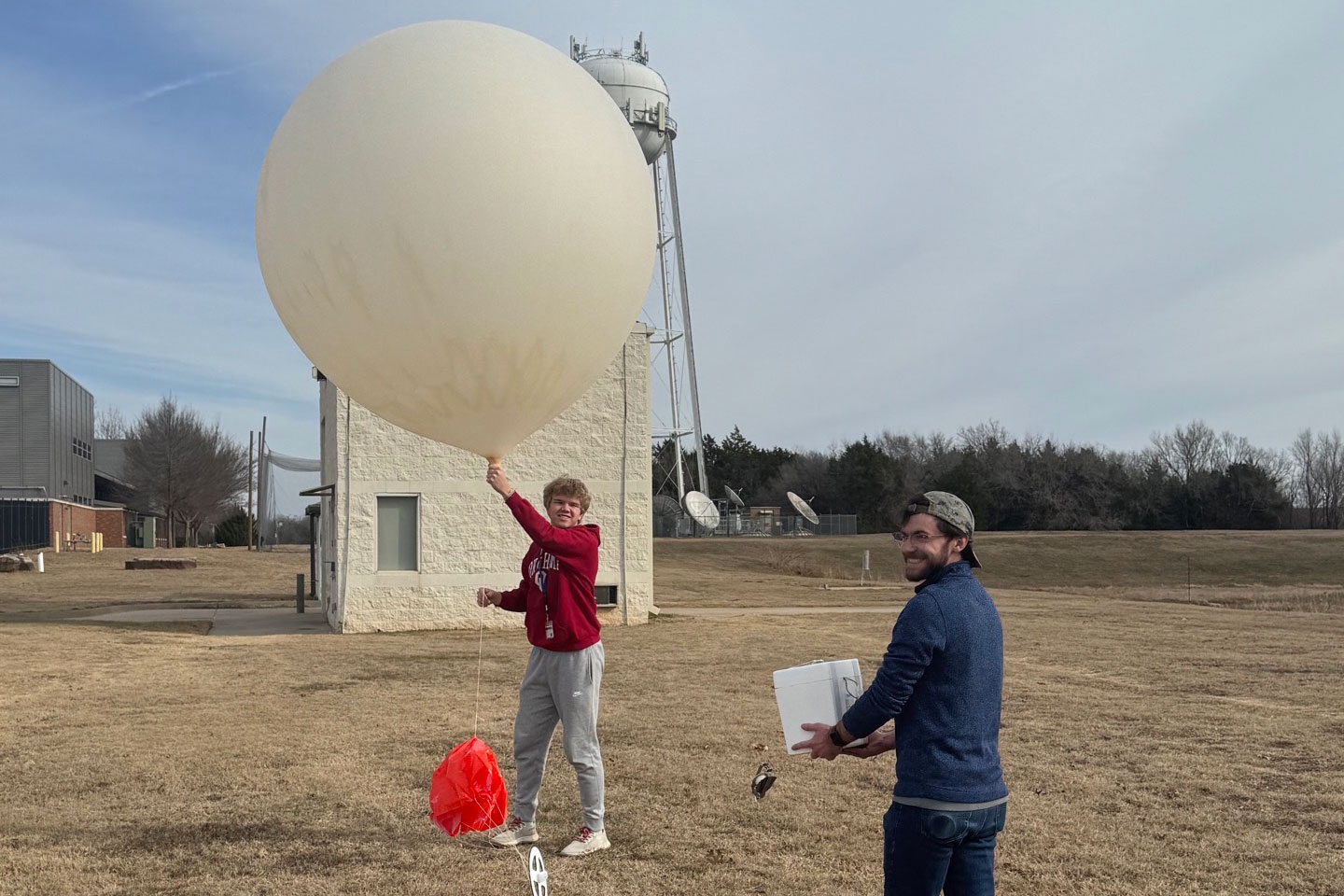 Two students launch a weather balloon. 