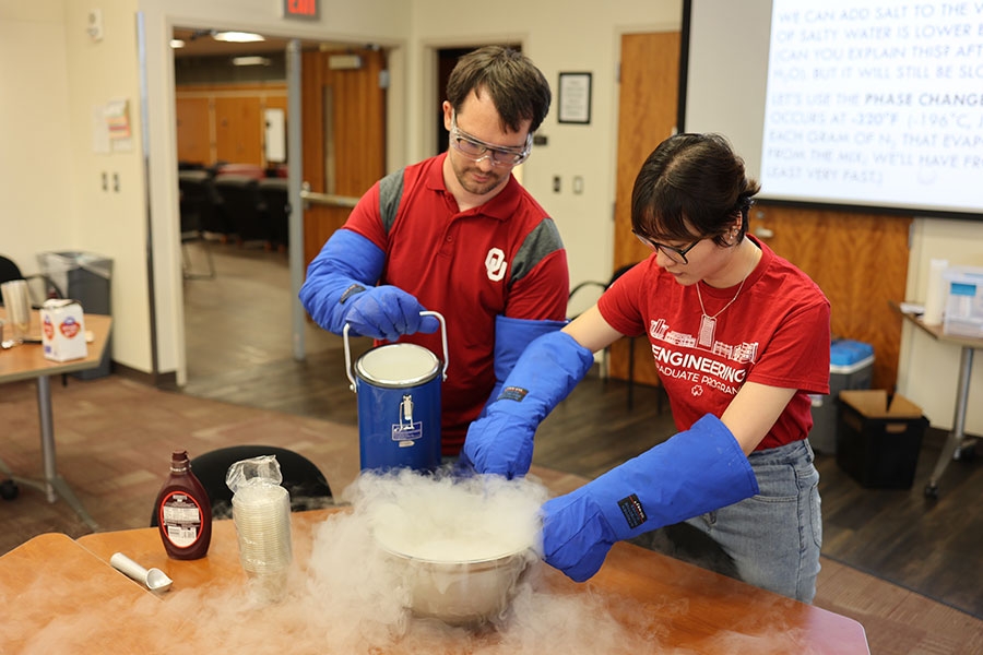 Students pour liquid nitrogen into a bowl.