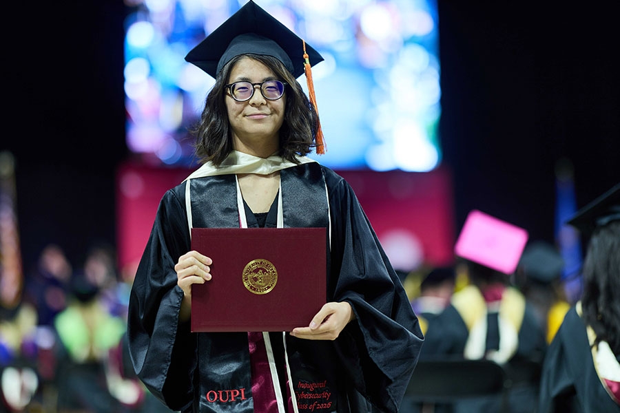 A graduate holding a diploma cover.