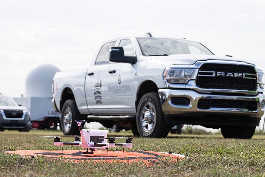 A drone sitting on a pad in front of a truck.
