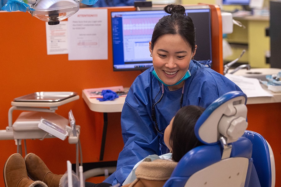 A dentistry employee smiles at a child.
