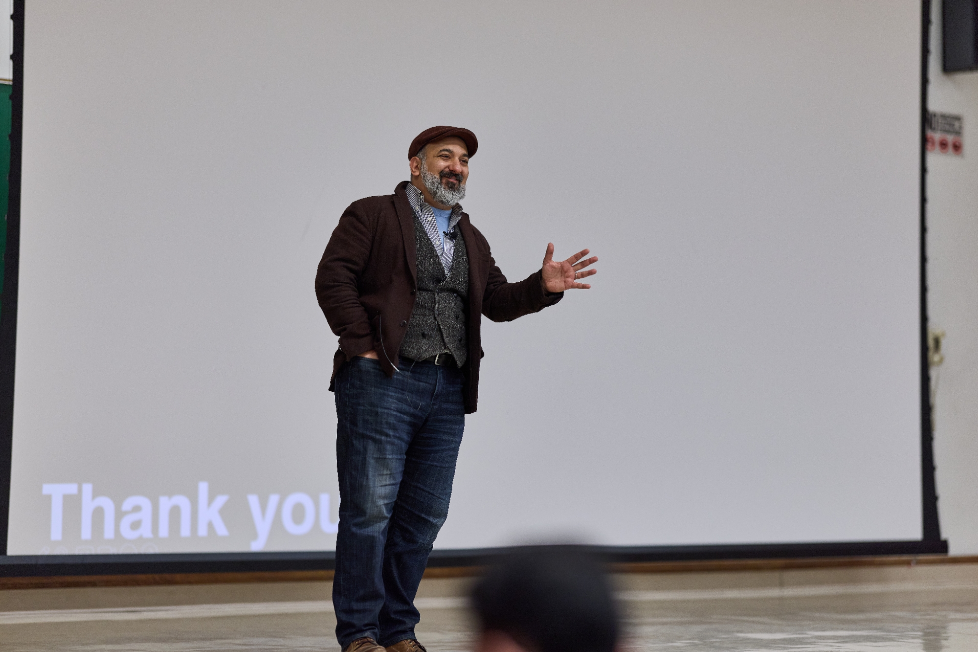A man standing in front of a screen that says "Thank you."