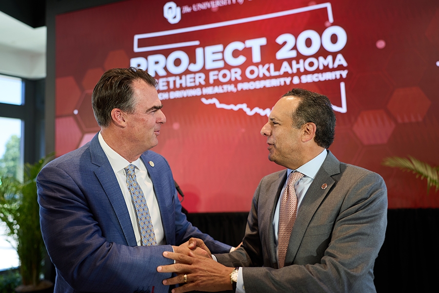 Photo of Oklahoma Governor Kevin Stitt and OU President Joseph Harroz Jr. shaking hands.. 