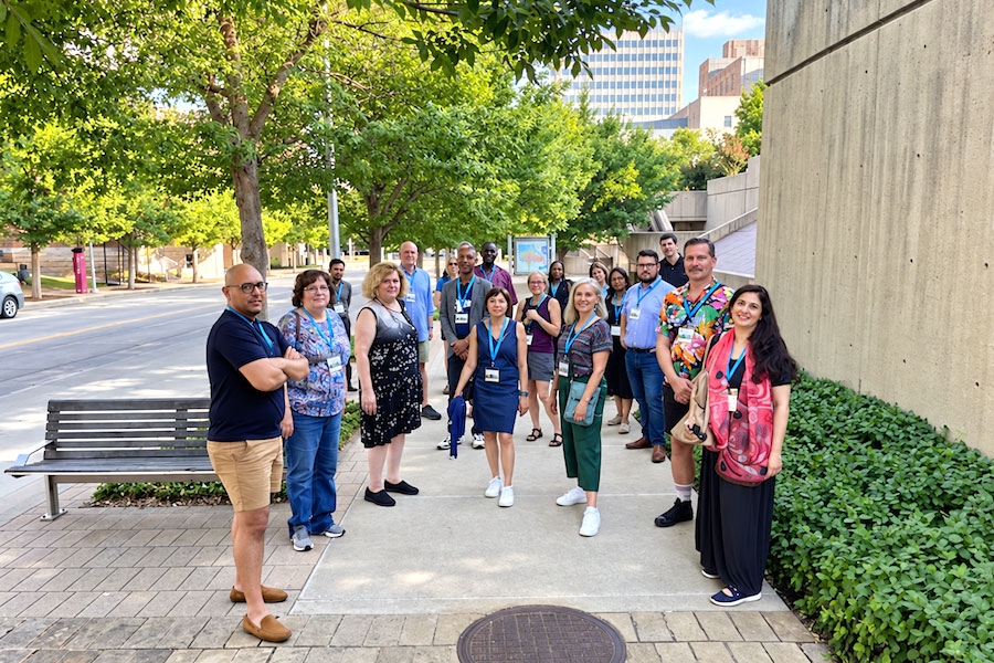 A group of people posing for a photo on a city sidewalk.