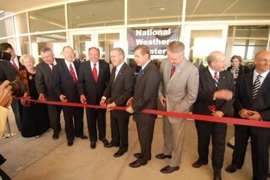Federal, state, academic, and industry weather partners cutting a red ribbon.