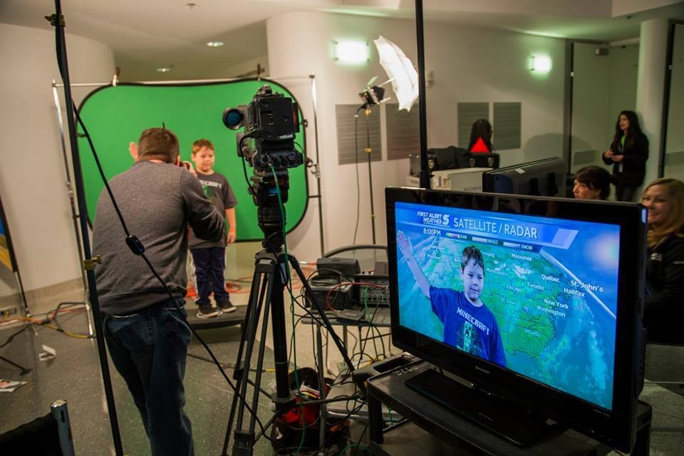 A 2019 National Weather Festival visitor practices giving a forecast in front of a green screen. (Image courtesy: NSSL Flickr), First Alert 5, Satellite/Radar, Minecraft