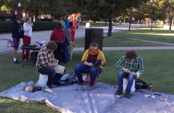 Students flintknap at event for OAM